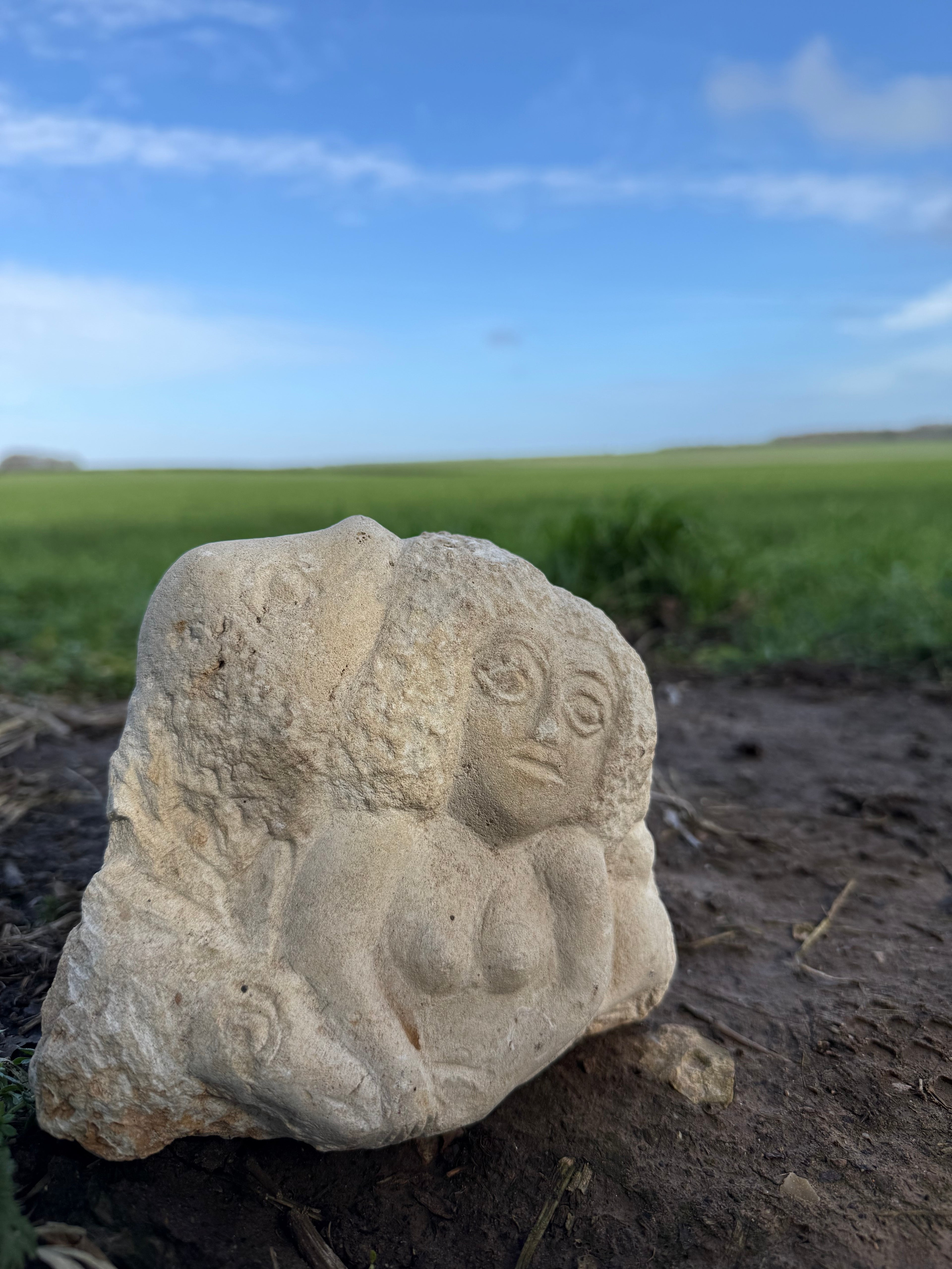 Limestone carved woman carrying sheep