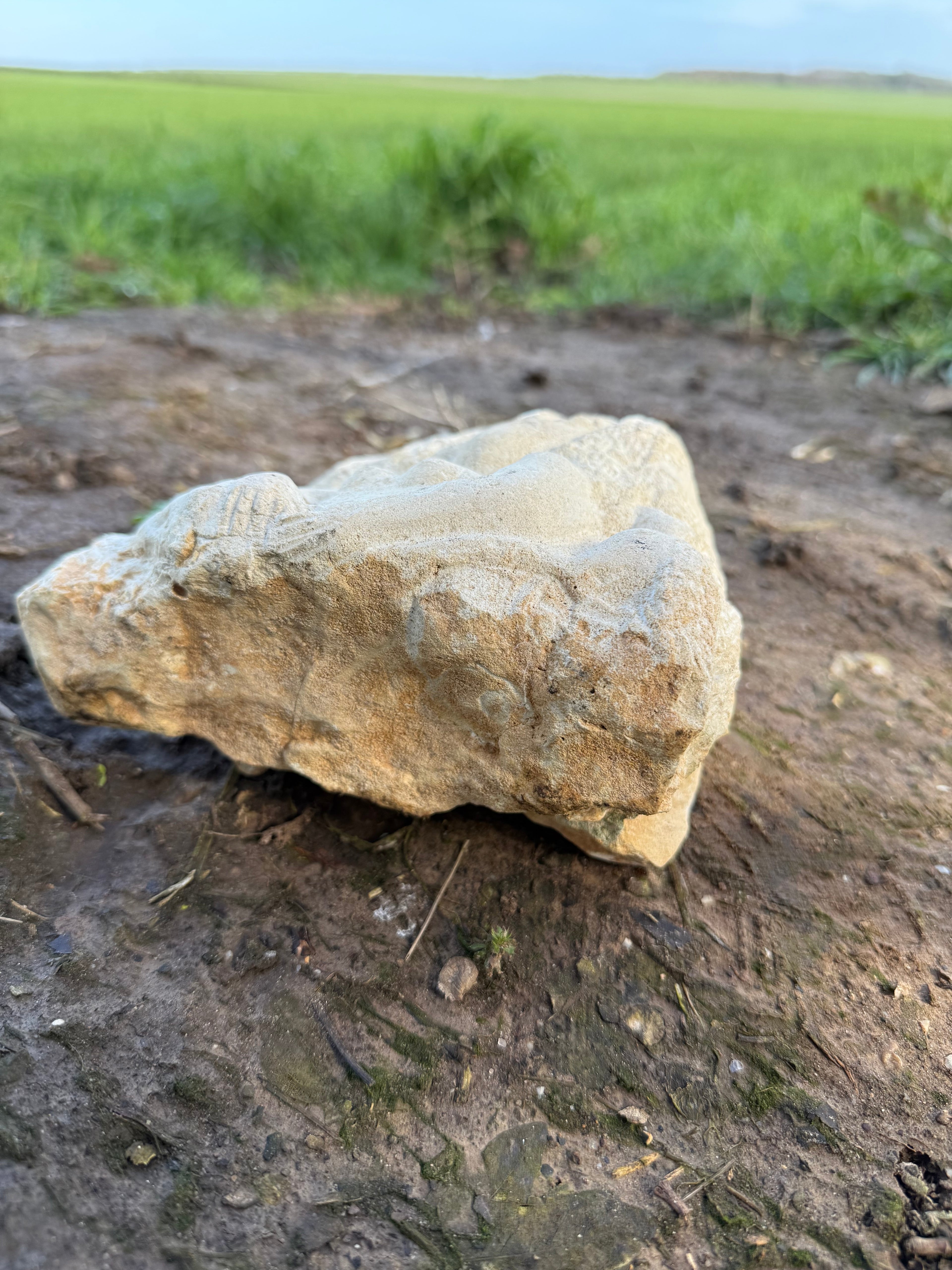 Limestone carved woman carrying sheep